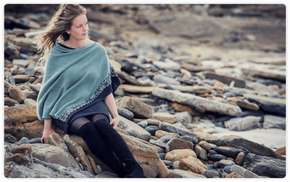 Lady wearing teal shall sitting on rocks Lady wearing teal shall sitting on rocks